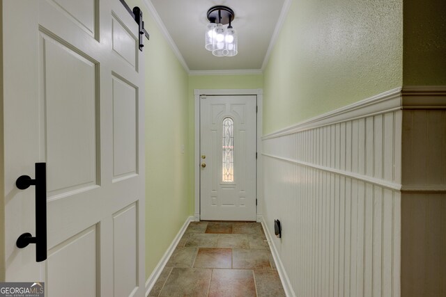 doorway to outside featuring a barn door and ornamental molding