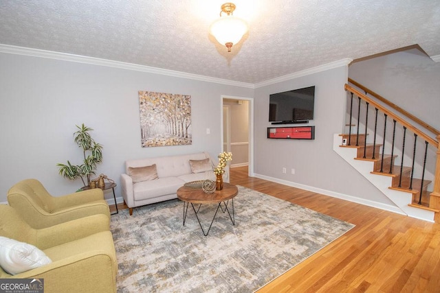 living room featuring a textured ceiling, ornamental molding, and hardwood / wood-style floors