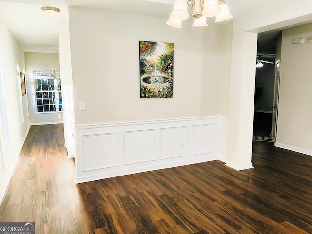 hallway featuring dark hardwood / wood-style flooring and an inviting chandelier