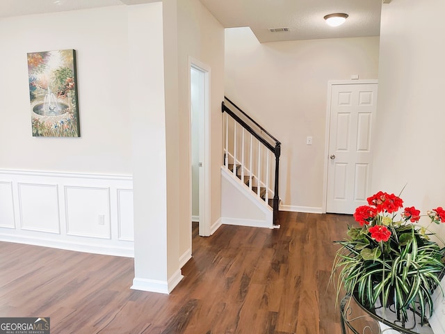 entrance foyer featuring a textured ceiling and dark hardwood / wood-style floors