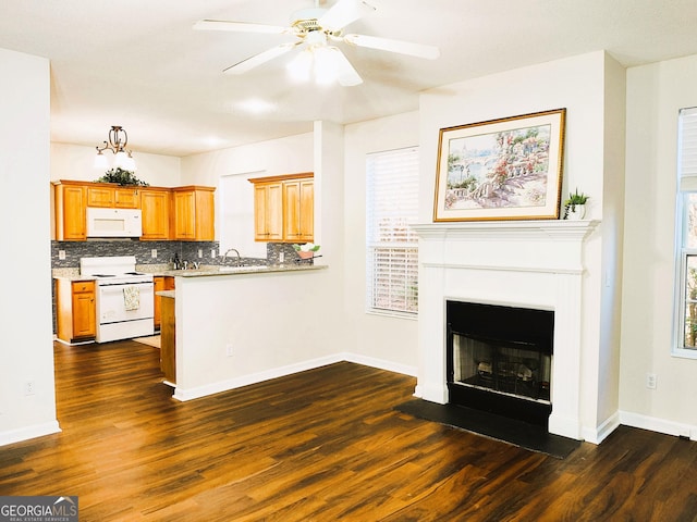 kitchen featuring ceiling fan, sink, dark wood-type flooring, backsplash, and white appliances