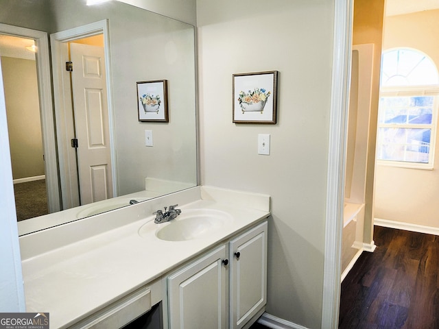 bathroom featuring a bathtub, hardwood / wood-style floors, and vanity