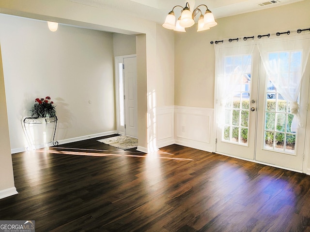 interior space with a notable chandelier, dark wood-type flooring, and french doors