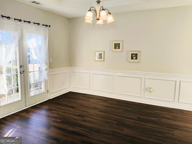 unfurnished dining area with french doors, a chandelier, and dark hardwood / wood-style floors