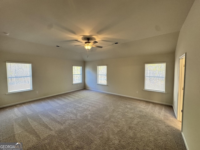 empty room with plenty of natural light, ceiling fan, and light carpet