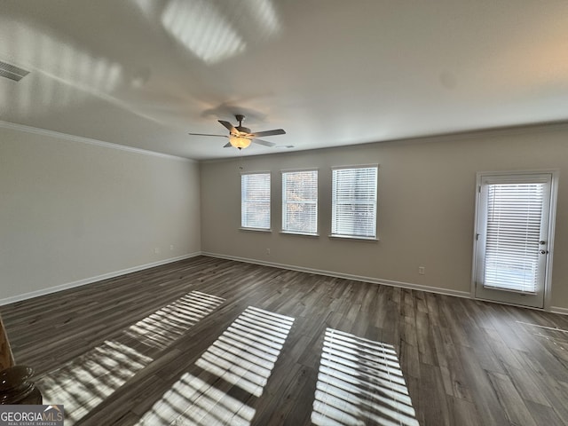 empty room with ceiling fan, dark hardwood / wood-style floors, and ornamental molding