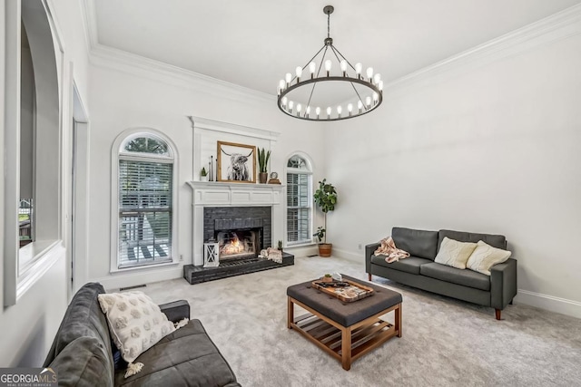 carpeted living room featuring a fireplace, a chandelier, and crown molding