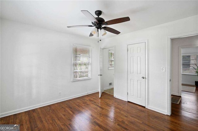 unfurnished bedroom with ceiling fan and dark hardwood / wood-style flooring