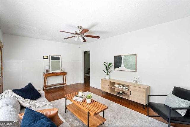 living room with dark hardwood / wood-style floors and ceiling fan