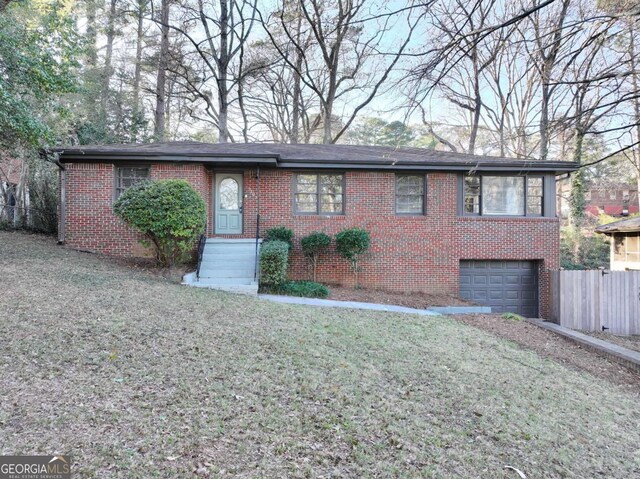 ranch-style house with a garage and a front lawn