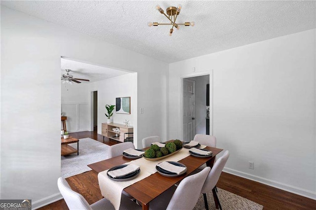 dining space featuring dark hardwood / wood-style floors, a textured ceiling, and ceiling fan with notable chandelier