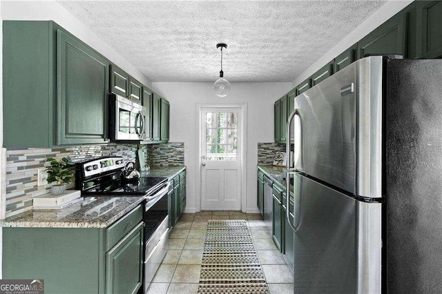 kitchen featuring pendant lighting, green cabinets, light tile patterned floors, and stainless steel appliances