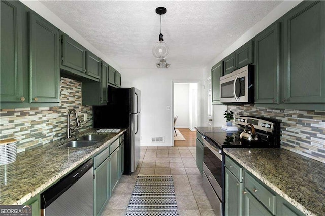 kitchen featuring decorative light fixtures, sink, stainless steel appliances, and green cabinetry