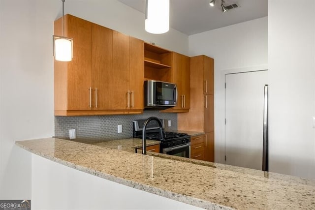 kitchen featuring decorative backsplash, light stone countertops, kitchen peninsula, and gas range