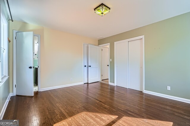 unfurnished bedroom featuring a closet and dark hardwood / wood-style floors