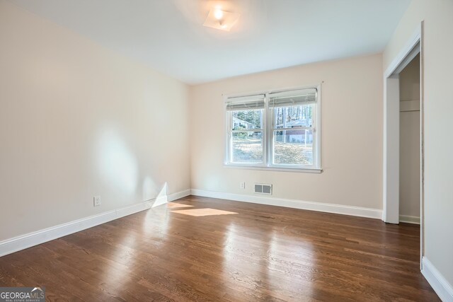 spare room featuring dark wood-type flooring