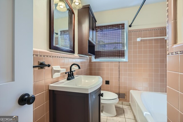 bathroom with tile patterned floors, vanity, toilet, and tile walls