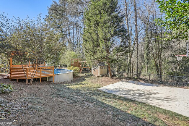 view of yard featuring a swimming pool side deck and a shed