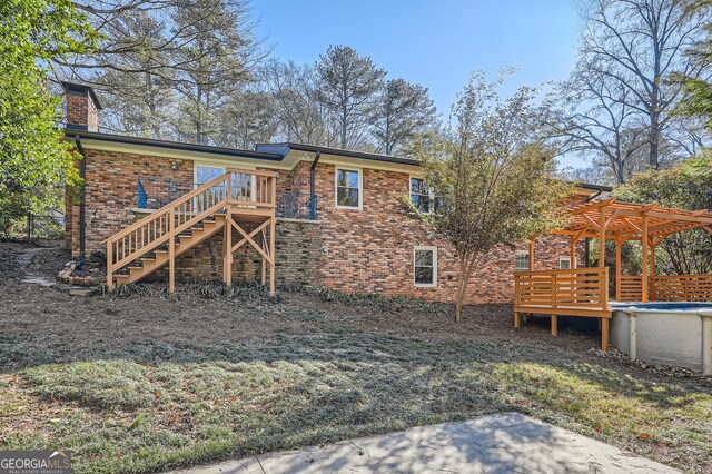 back of house featuring a pergola and a swimming pool side deck