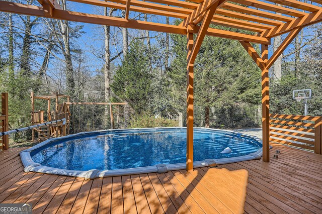 view of pool featuring a pergola and a wooden deck