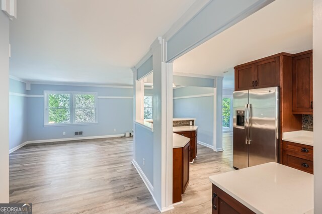 kitchen with backsplash, stainless steel fridge, and light hardwood / wood-style flooring