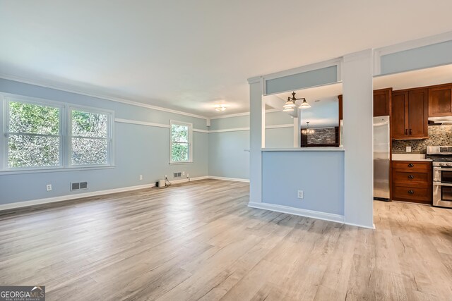 unfurnished living room featuring crown molding and light hardwood / wood-style floors