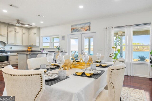 dining area with dark hardwood / wood-style floors, plenty of natural light, and crown molding