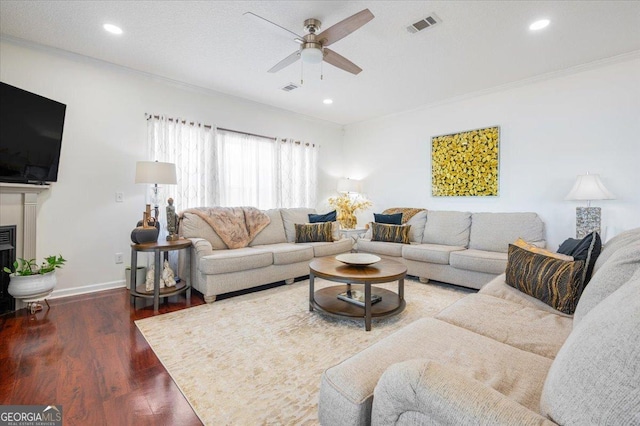 living area featuring wood finished floors, visible vents, recessed lighting, ceiling fan, and crown molding