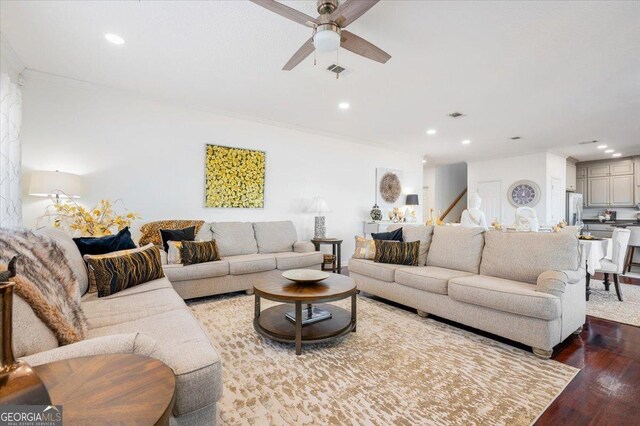 living room with hardwood / wood-style flooring, ceiling fan, and crown molding