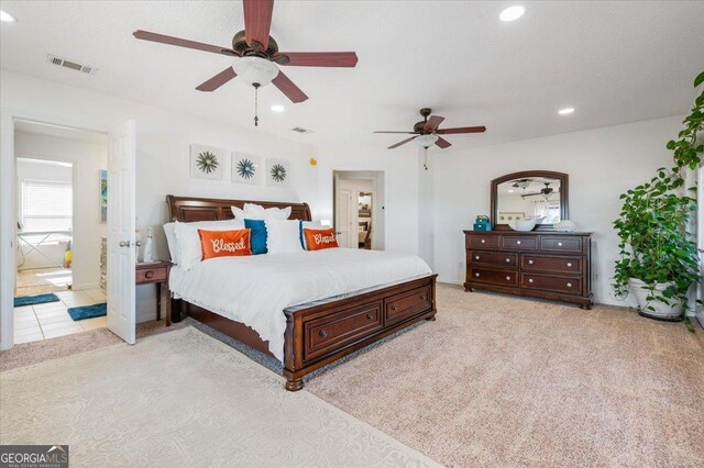 carpeted bedroom with connected bathroom and ceiling fan