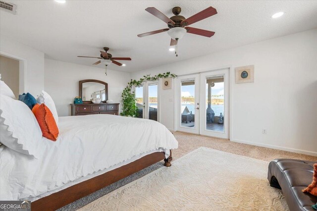 carpeted bedroom featuring french doors, access to outside, ceiling fan, and a water view