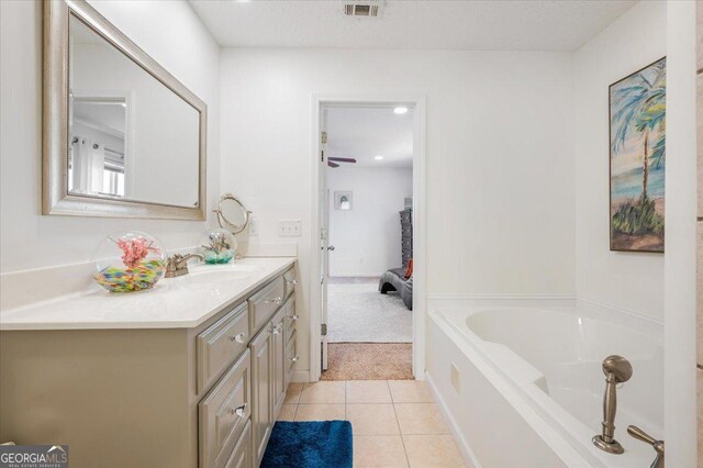 bathroom with a tub, ceiling fan, tile patterned flooring, and vanity