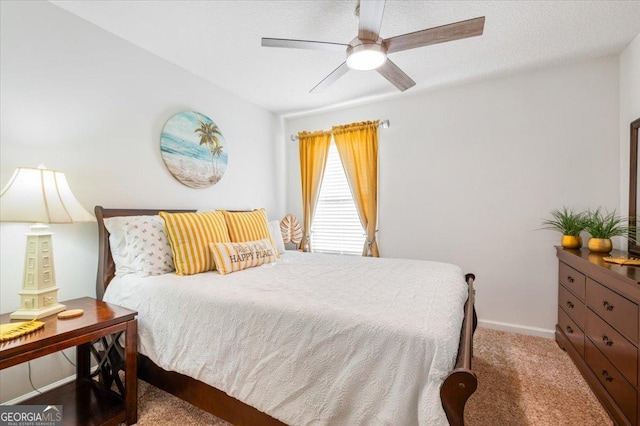 carpeted bedroom featuring baseboards and a ceiling fan