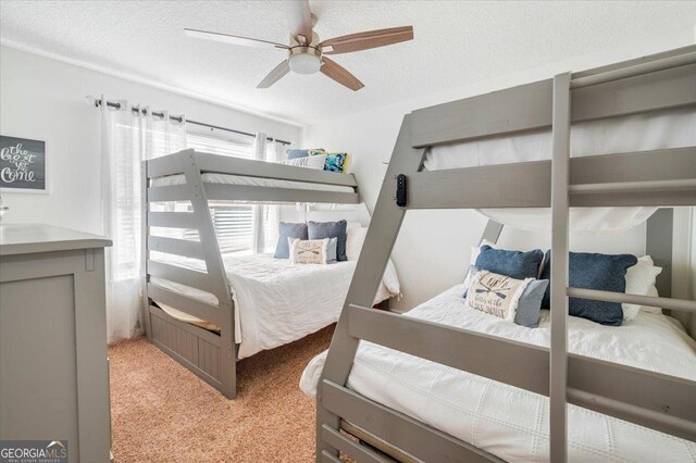 bedroom featuring ceiling fan, a textured ceiling, and light carpet