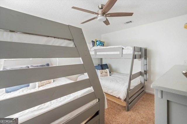 carpeted bedroom with ceiling fan and a textured ceiling