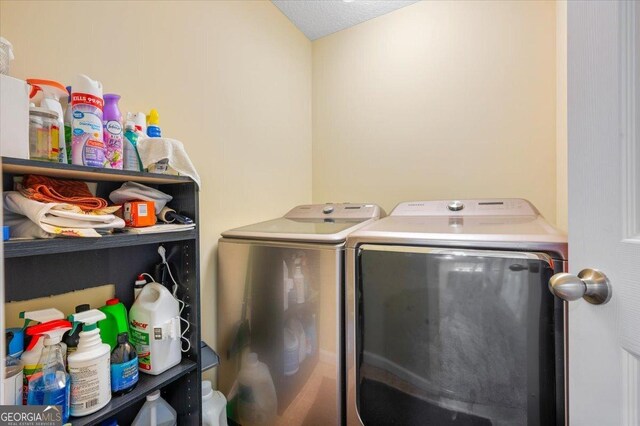 laundry room with a textured ceiling and washing machine and dryer