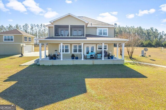 rear view of property featuring a lawn and french doors