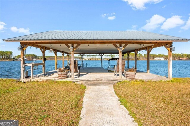 dock area with a water view and a lawn