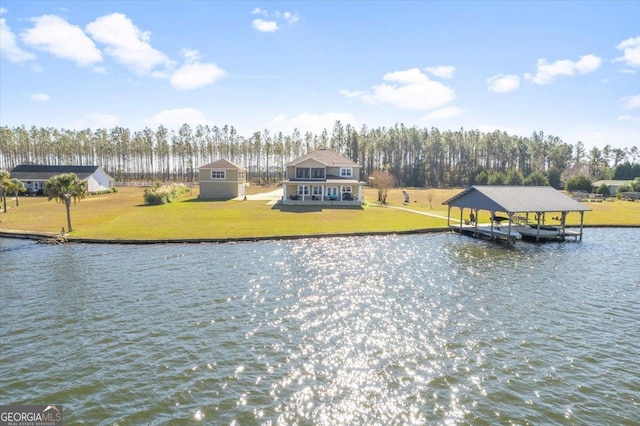 dock area with boat lift, a yard, and a water view