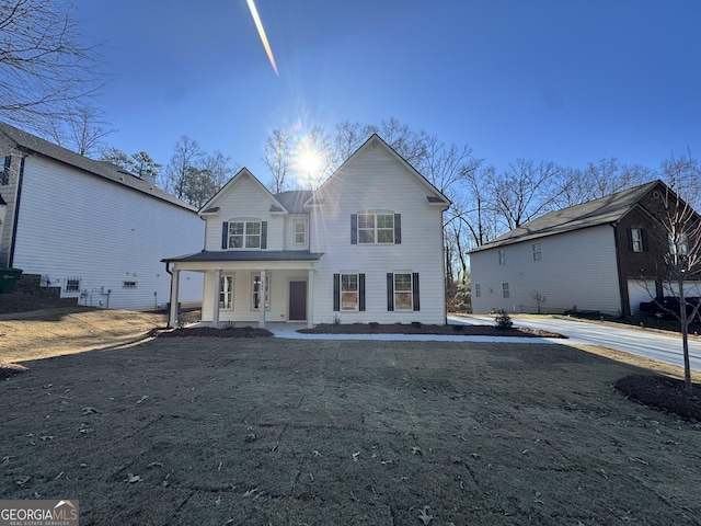 view of property featuring a porch and a front lawn