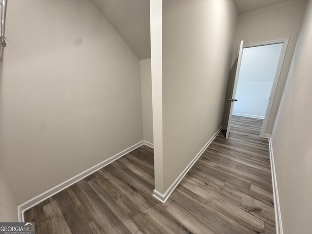 corridor featuring hardwood / wood-style floors and vaulted ceiling