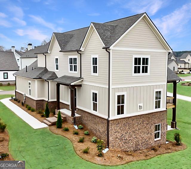 view of property exterior with a yard, a residential view, brick siding, and a shingled roof