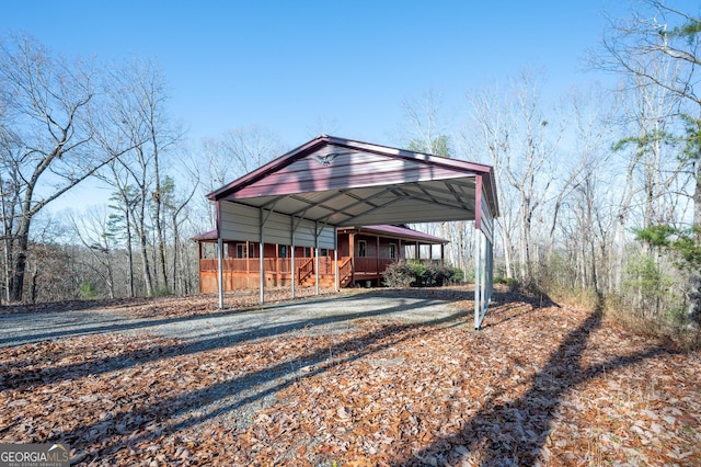 back of house featuring covered porch and a carport