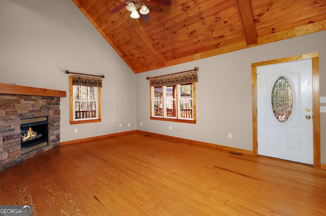 unfurnished living room featuring hardwood / wood-style flooring, a stone fireplace, ceiling fan, and wooden ceiling