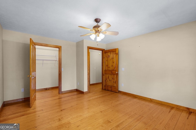 unfurnished bedroom with ceiling fan, a closet, and light wood-type flooring