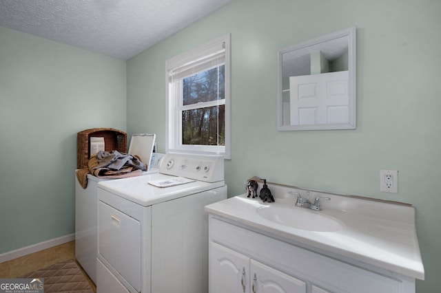 clothes washing area with cabinets, a textured ceiling, sink, light tile patterned floors, and separate washer and dryer