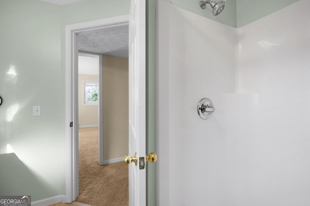 bathroom featuring a textured ceiling and walk in shower