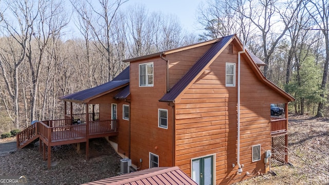 view of side of property featuring a deck and central AC