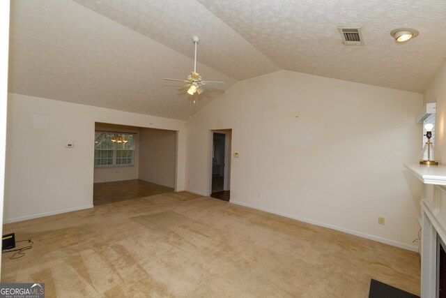 unfurnished living room with a textured ceiling, light colored carpet, and lofted ceiling