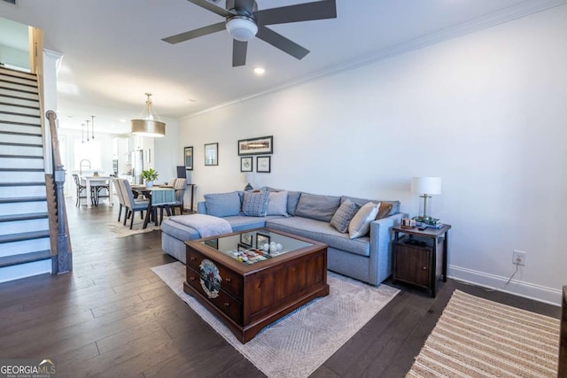 living room featuring ceiling fan, crown molding, and dark wood-type flooring